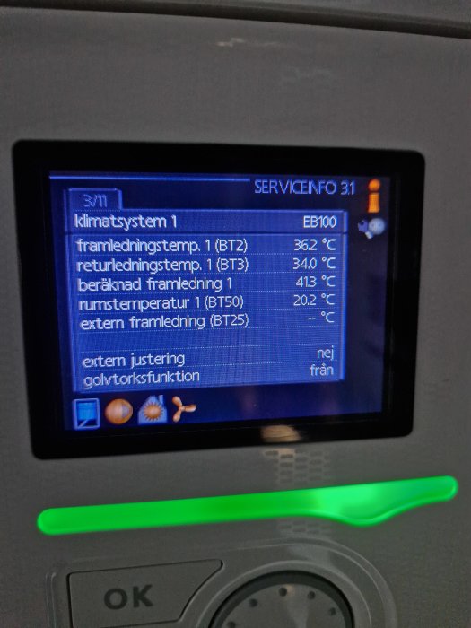 Digital skärm som visar temperaturinformation för ett klimatsystem, med grönt lysande indikatorljus nedanför.
