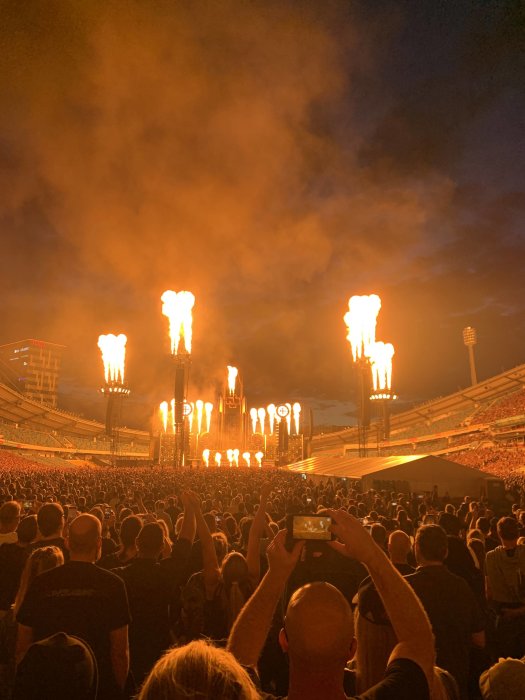 Konsert med entusiastisk publik och imponerande eldeffekter på stadion i kvällsskymningen.