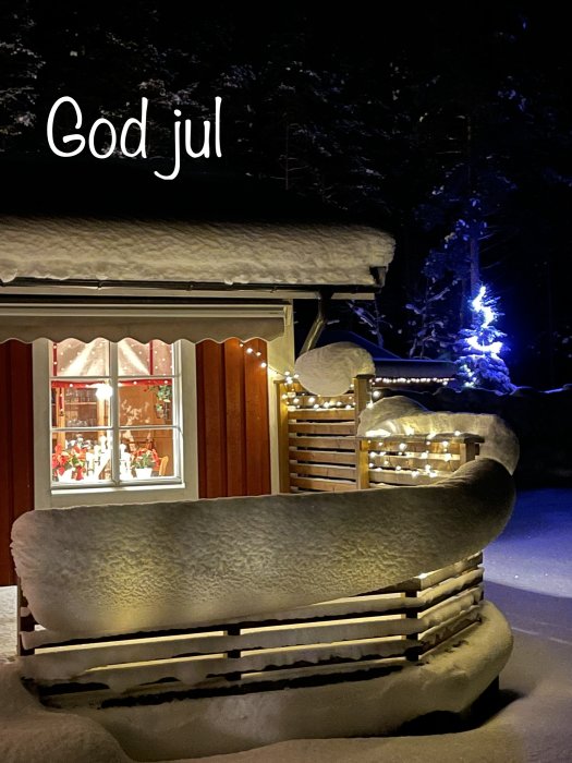 Vinterkväll med snötäckt bänk, julbelysning, "God jul"-text och mysig stämning.