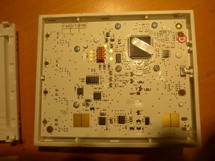 Elektronikkort i öppnat vit plastytterhölje med många komponenter och en central processor.