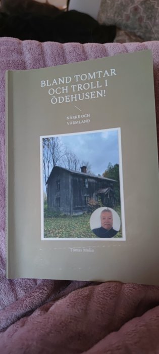 Bokomslag med titeln "Bland tomtar och troll i ödehusen", övergivet hus och mansporträtt, Tomas Molin.