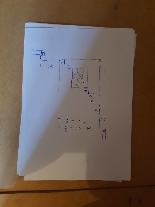 Handritad skiss över en rumsplanlösning med måttangivelser och detaljer som dörr, fönster och radiatorer.