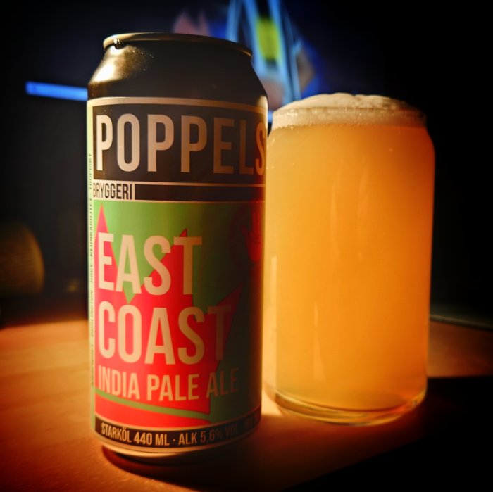 Ölburk med texten "Poppels Bryggeri East Coast India Pale Ale" bredvid glas fylld med öl.