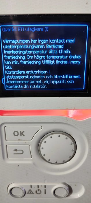 Felmeddelande på värmepumps display; instruktion att kontrollera anslutning och återställa larm.