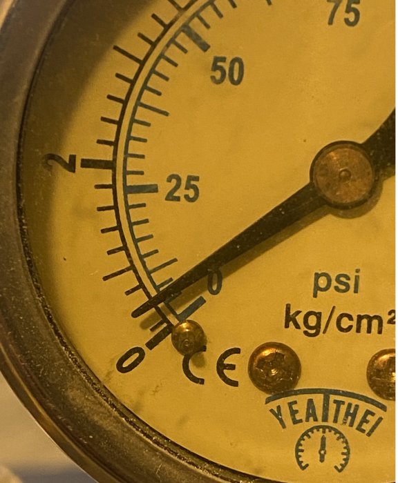 Analogt tryckmätare med mätenheter i psi och kg/cm², gammal och sliten, närbild, industriell.