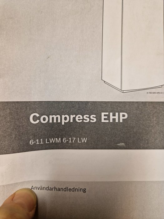 En hand håller en sida av en manual för "Compress EHP" med delvis synliga diagram och texter.