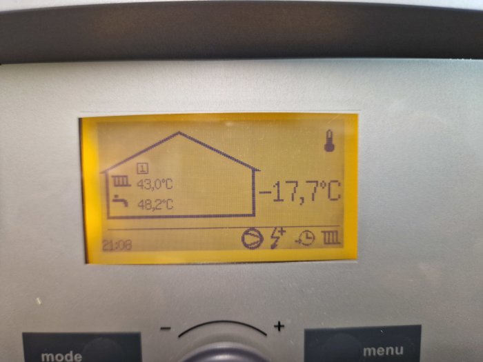 Digital termostat visar inomhus- och utomhustemperatur med ikoner för väderprognos och batteristatus.