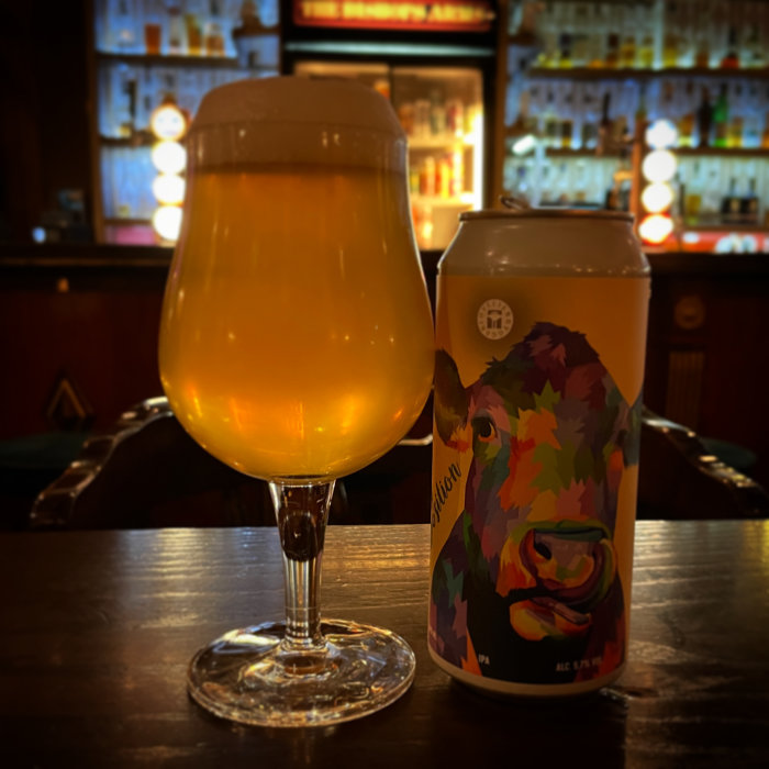 Ett ölglas och en burk med färgglad ko-design på en barbakgrund.