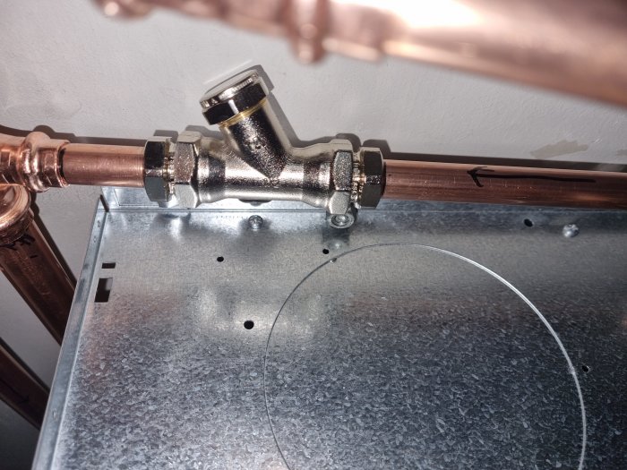 Kopparledningar, avstängningsventil, flödesriktning, VVS-installation, metallplatta, teknisk utrustning.