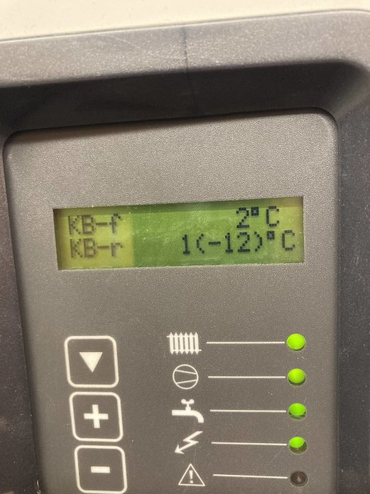 Digital termostatvisning med temperatur mellan 20°C och 1-12°C, knappar, symboler, grön bakgrundsbelysning.
