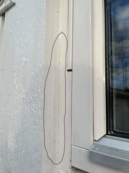 Slitet fönsterkarm, vitmålad, med en spricka markerad för reparation.