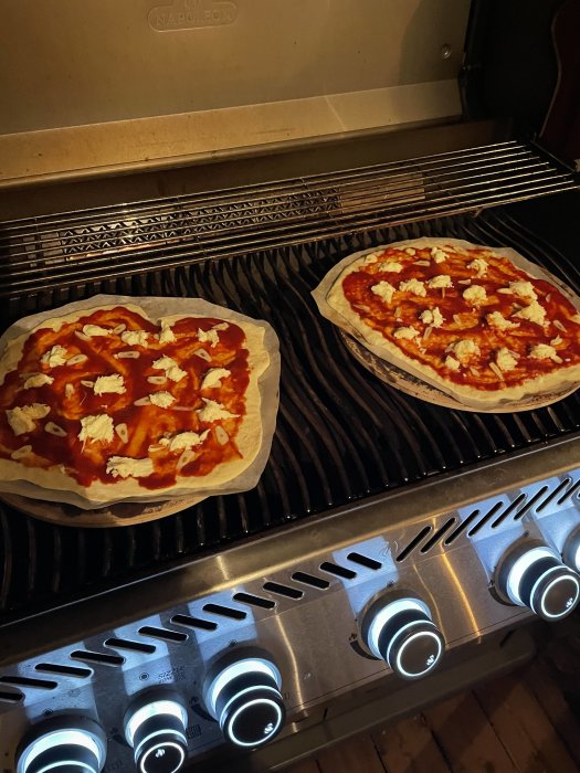 Två ost- och tomatsåspizzor grillas i en gasgrill.