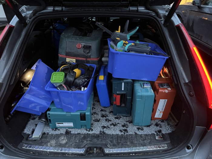 Bilens bagageutrymme fullt med verktyg och förvaringslådor, ger intryck av hantverkarens mobil arbetsstation.