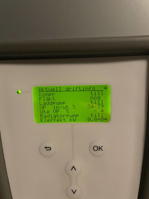Digitalt kontrollpanel för värmesystem med skärminformation och navigationsknappar.