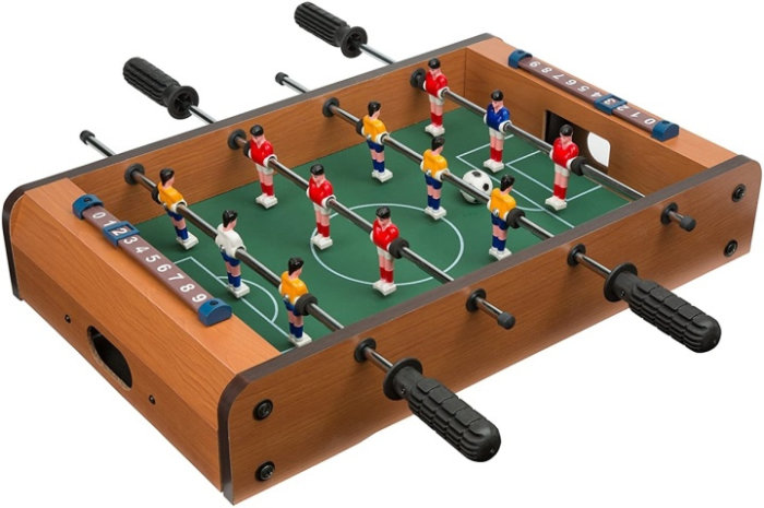 Ett bordfotbollsspel med färgglada figurer, poängräknare och svarta handtag för spel.