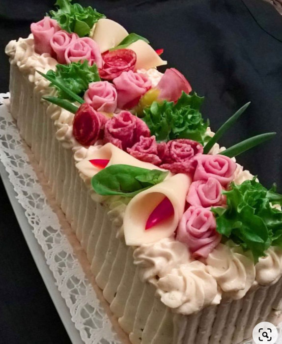 Tårta dekorerad som en blomsterbukett med rosor och blad, kreativ konditorikonst.