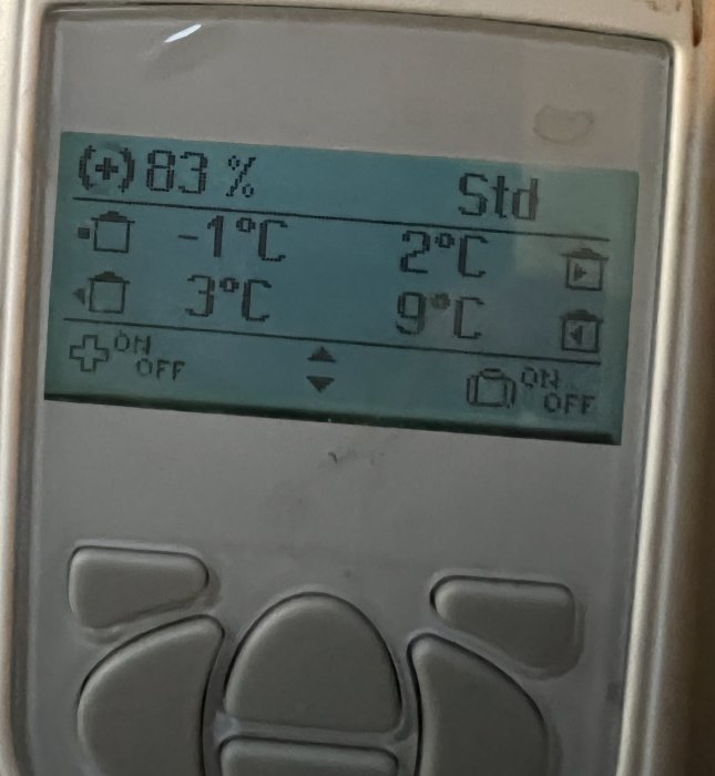 Digital termostat visar temperaturinställningar och batterinivå på upplyst display.