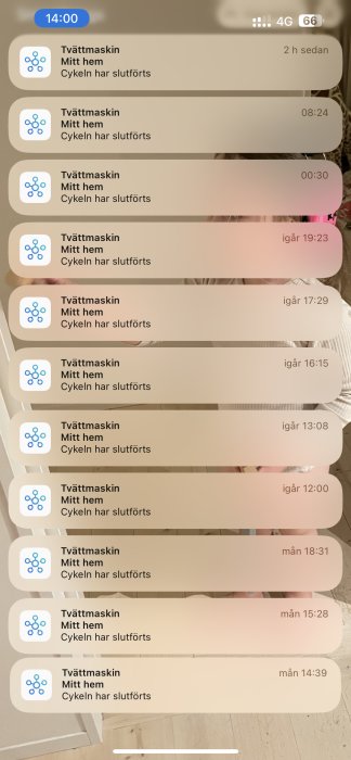 En serie notifikationer om avslutade tvättmaskinscykler på en mobiltelefon, speglande i bakgrunden.