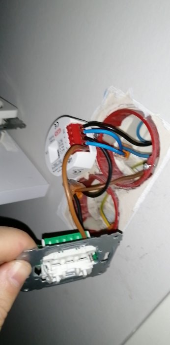 Öppen elektrisk dosa med kablar och strömbrytare under installation eller reparation inomhus. Oskarp och vinkelvrängd bild.