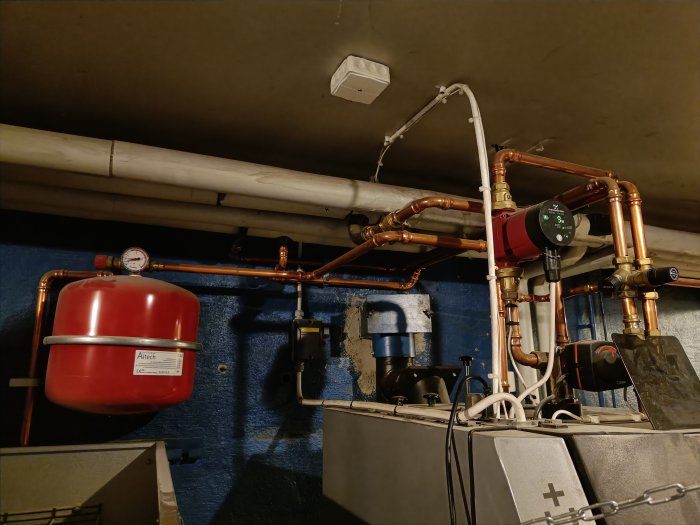 Värmeanläggning med rör, cirkulationspump, expansionskärl och mätinstrument i en teknisk installation.