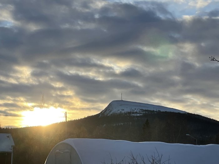 Solnedgång, molnigt himmel, snötäckt berg, antenntorn, vinterskymning, otydligt landskap, softa färger, natur, fridfullt.