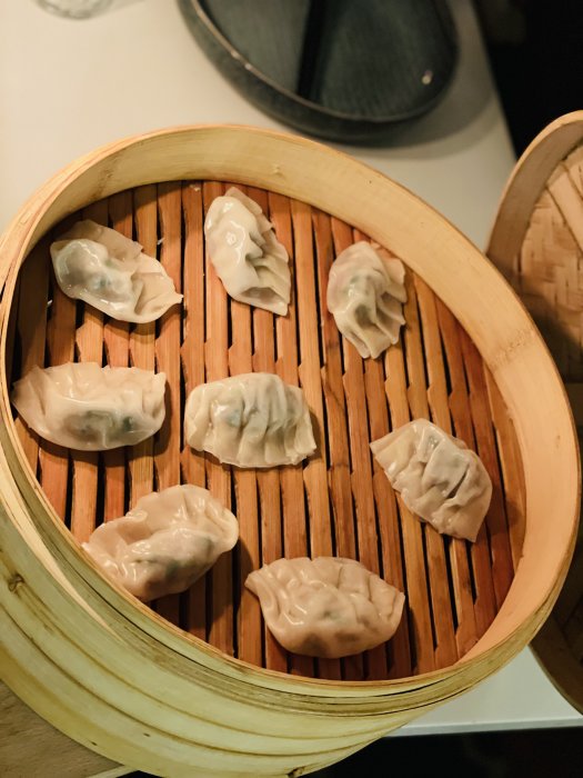 Ångade dumplings i bambukorg, asiatiskt kök, hemlagade eller restaurangmat, traditionella knyten, ångkokning.