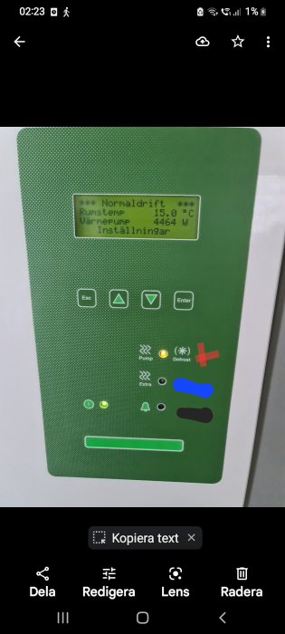 Digital kontrollpanel för värmeanläggning med temperatur och effektvisning, larm- och statusikoner.