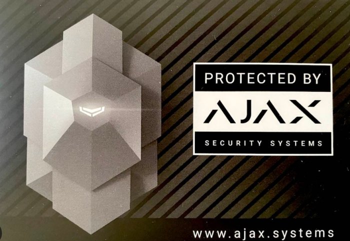 Etikett med text "PROTECTED BY AJAX SECURITY SYSTEMS" bredvid abstrakt geometrisk figur.