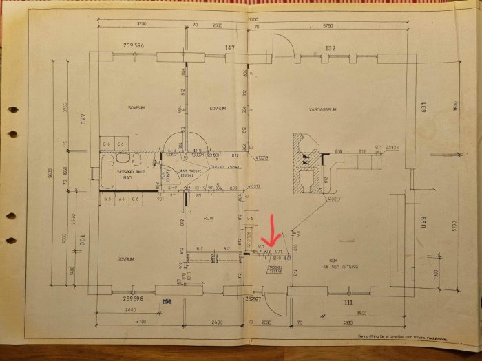 Gammal arkitektritning, planlösning, markerad med röd pil, sovrum, badrum, vardagsrum, kök.