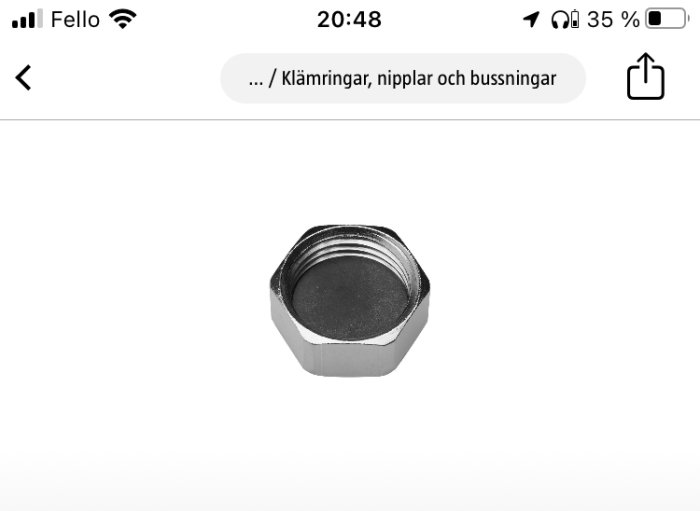 Hexagonal metallisk rördel, förmodligen plug eller lock, med gänga, på vit bakgrund.