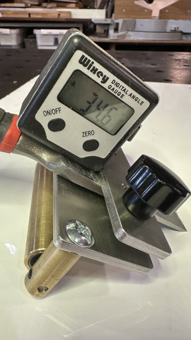 Digital vinkelmätare fäst på metallstycke visar 31,5 grader i verkstadsmiljö.