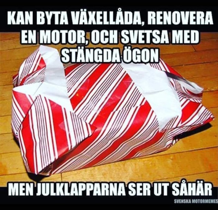 Slarvigt inslagen julklapp med humoristisk text om tekniska färdigheter versus presentinslagning. Rödvit randig.