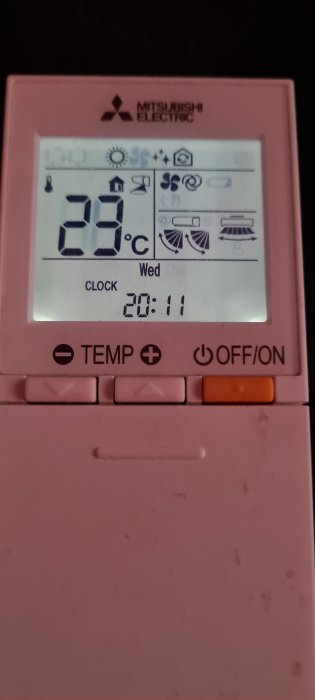 Mitsubishi Electric fjärrkontroll, visar 23 grader Celsius, klockan 20:11 på en onsdag. Luftkonditioneringssymboler synliga.