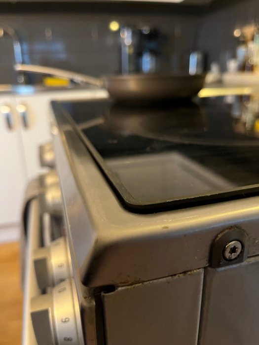 Förgrundsfokus på spishörn, suddig bakgrund, köksinredning, spisvred i framkant.