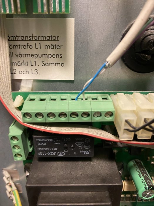 Elektronikkomponenter, kretskort, transformator, anslutningsterminaler, etikett med instruktioner, kablar.