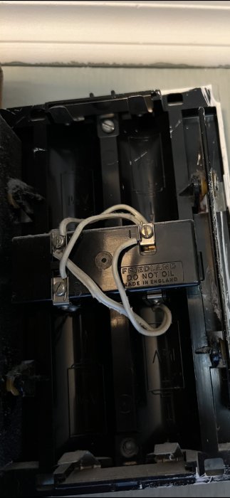 Öppen elektrisk enhet, möjligen en klocka eller ringklocka, med texten "Friedland DO NOT OIL Made in England".