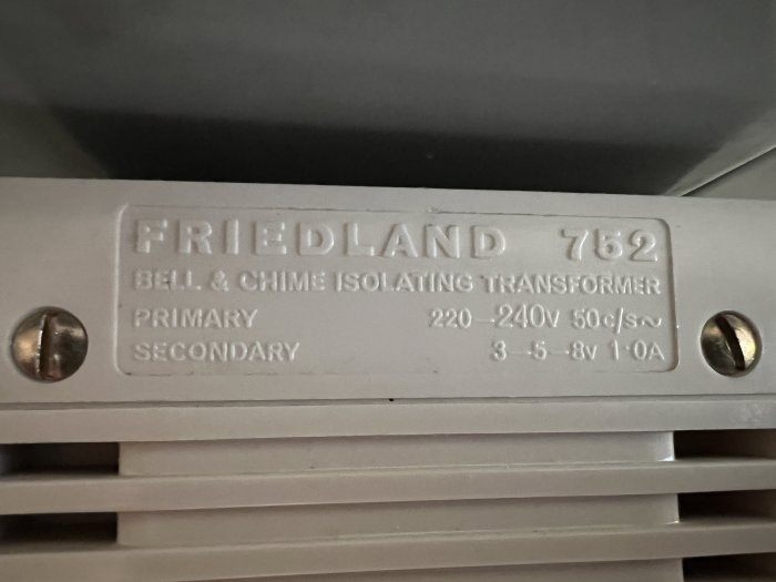 Etikett på isolertransformator för dörrklocka, Friedland 762, specifikationer för spänning och ström.