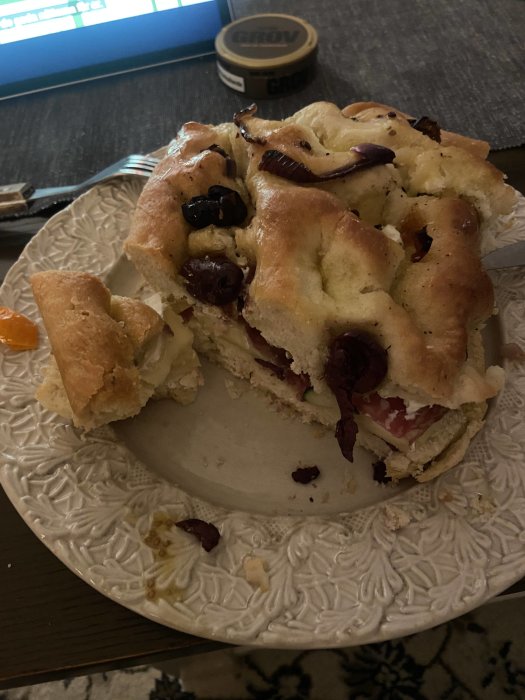Halväten paj med körsbär på dekorerad tallrik, snussats syns i bakgrunden.