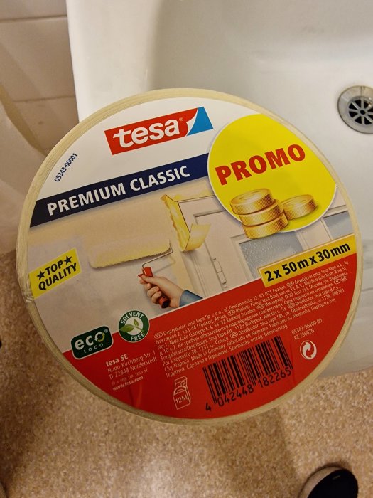 Två rullar Tesa Premium Classic tejp, målartillbehör, gul etikett indikerar kampanj, ECO-logotyp, lösningsmedelsfri.