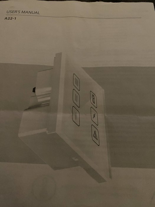 Svartvit bild av en öppnad handbok med genomskinlig plastkontroll påsidan.