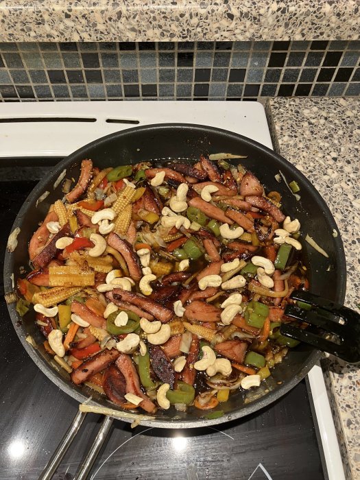 Stekpanna med asiatiskt inspirerad mat, grönsaker, cashewnötter och strimlat kött.