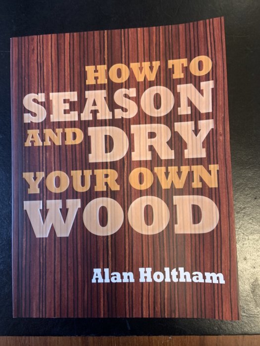 Bokomslag med titeln "How to Season and Dry Your Own Wood" av Alan Holtham, träbakgrund.