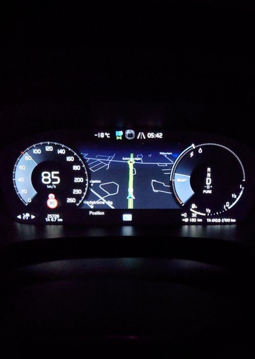 Bilens instrumentpanel nattetid visar hastighet, navigation och temperatur, modern och digital.