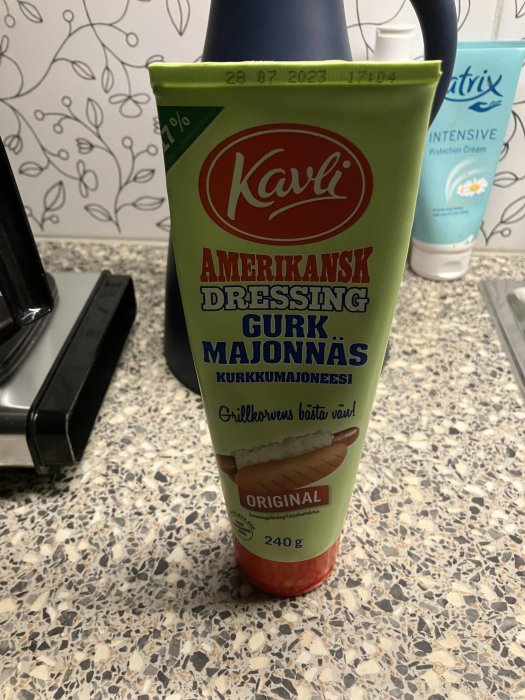 Tub med Kavli amerikansk dressing och gurkmajonnäs på bänkskiva, köksmiljö, 240 g, grön etikett.