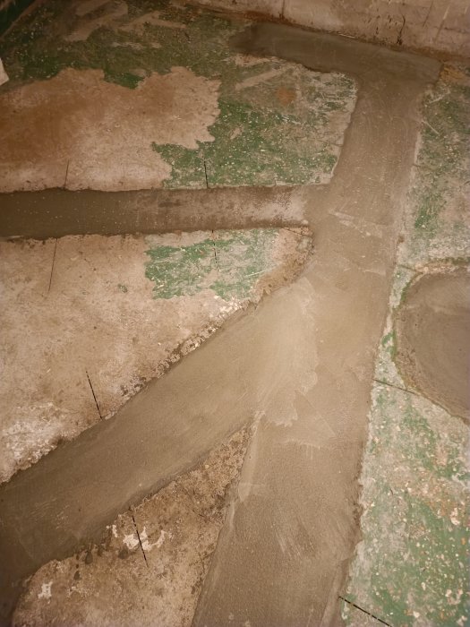 Gammal, sliten trappa med delvis avflagnad grön färg och betongreparationer.