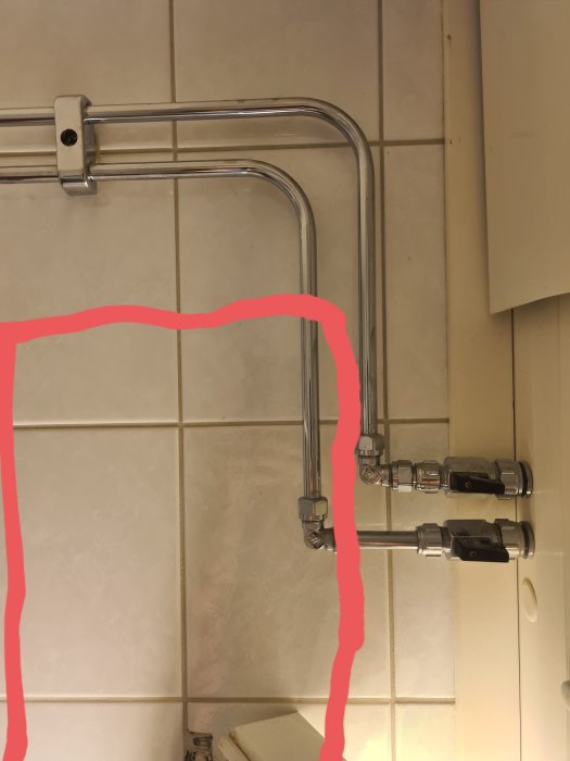 Rör och kranar i badrum med kakelvägg, handduksupphängning, markeringar i rött.