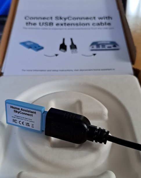 USB-förlängningskabel framför instruktioner för att ansluta "SkyConnect", del av en Home Assistant-uppsättning.