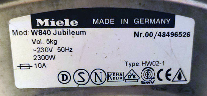 Typskylt på en Miele-produkt, modell W840 Jubileum, tillverkning i Tyskland, elektrisk information och certifieringssymboler.