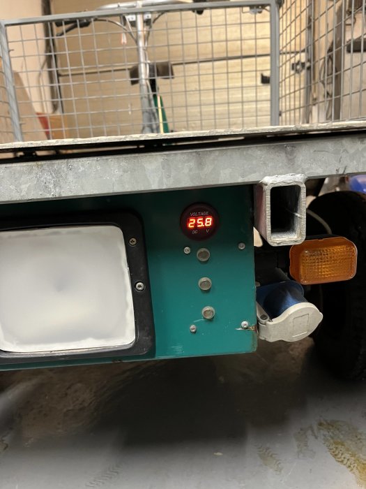 Elektronisk display på fordon visar 25.8 volt, metallram, handtag, reflekterande yta, delvis siktbar hjul.