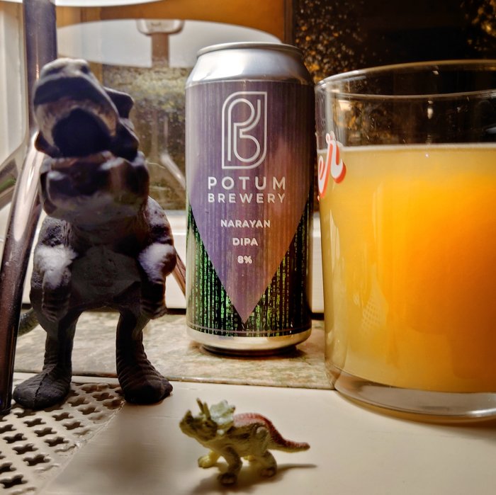 Ölburk från Potum Brewery, dinosaurieleksaker, glas juice på diskbänken, hemmiljö.